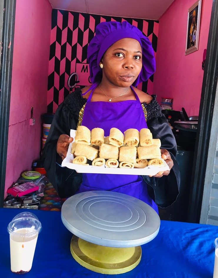 Baker_on_purple_apron_holding_fishroll